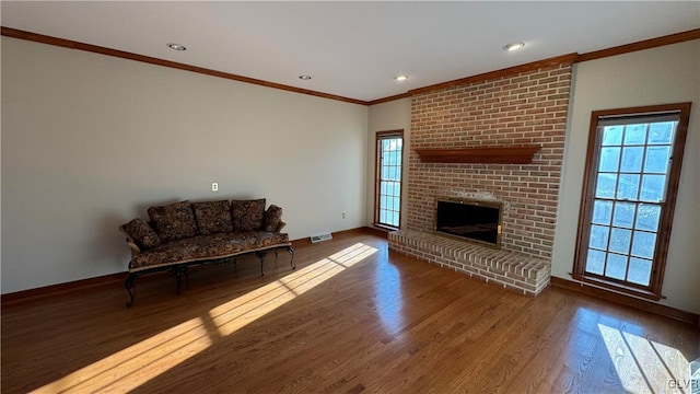 living room featuring a wealth of natural light, visible vents, and wood finished floors