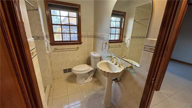 bathroom with tile patterned flooring, visible vents, walk in shower, toilet, and a sink