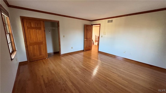 unfurnished bedroom with light wood-type flooring, visible vents, baseboards, and crown molding