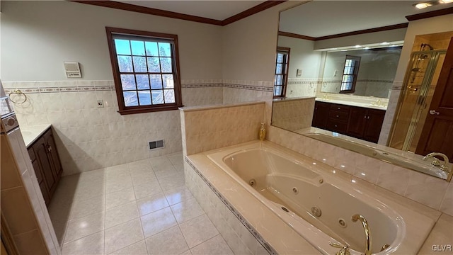 full bath with vanity, a tub with jets, tile patterned flooring, crown molding, and tile walls