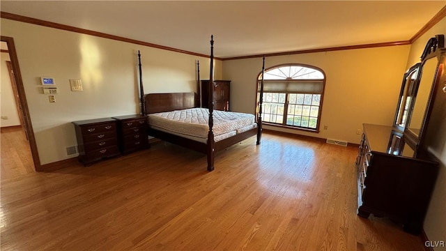 unfurnished bedroom featuring visible vents, ornamental molding, baseboards, and wood finished floors