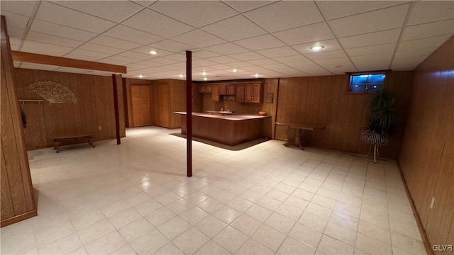 finished basement featuring light floors and wood walls