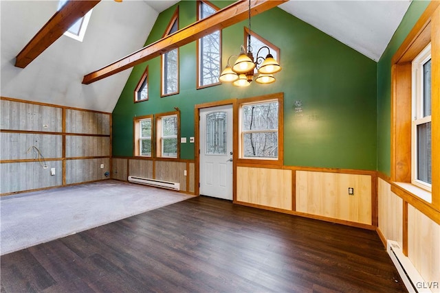 interior space with a baseboard heating unit, lofted ceiling with skylight, wainscoting, and a baseboard radiator