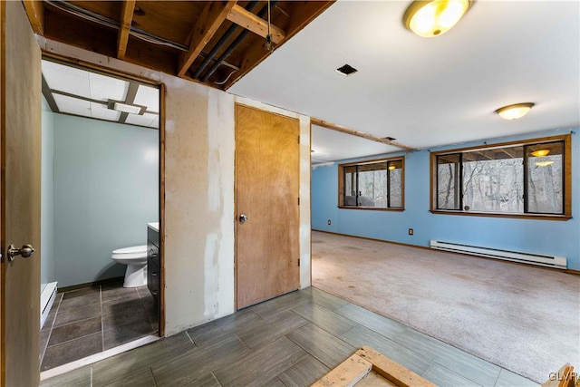 bathroom featuring baseboard heating, toilet, baseboards, and a baseboard radiator