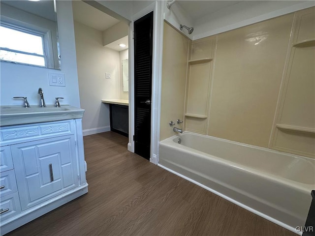 bathroom with vanity, shower / bathing tub combination, wood finished floors, and baseboards