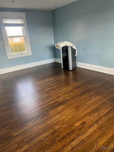 interior space with dark wood-type flooring and baseboards