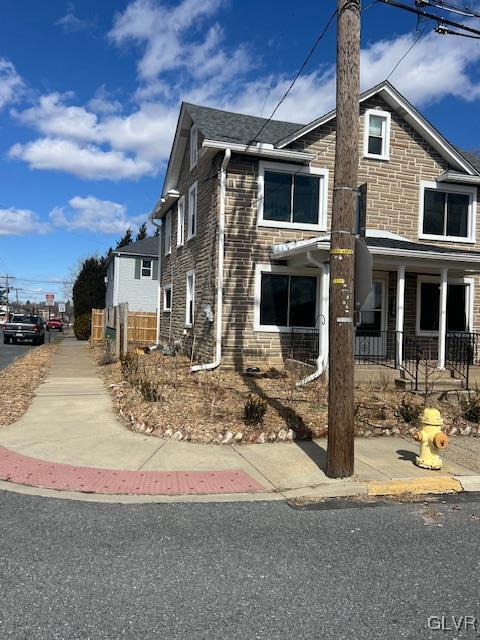 exterior space with stone siding and fence