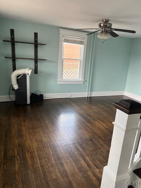 unfurnished living room with baseboards and wood finished floors