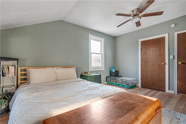 bedroom featuring ceiling fan, baseboards, lofted ceiling, and wood finished floors