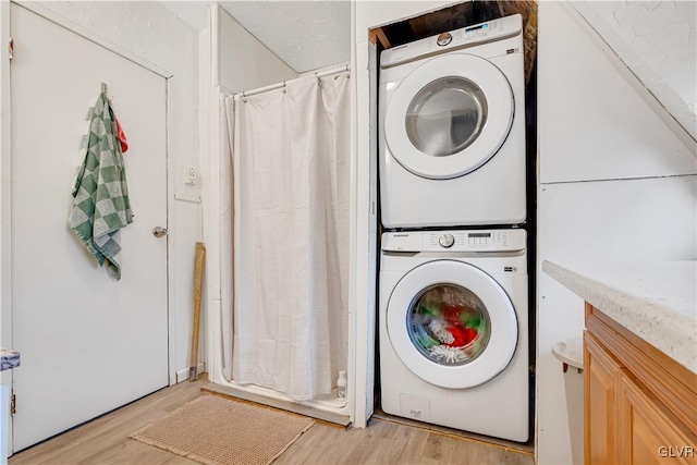 laundry area featuring light wood-style floors and stacked washer and dryer