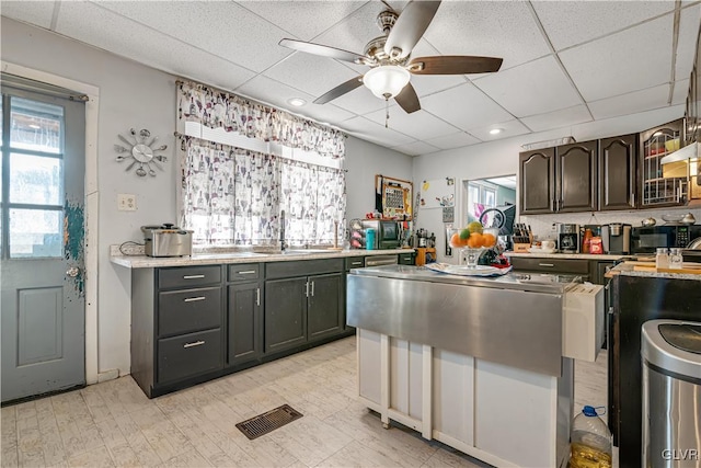 kitchen featuring a paneled ceiling, visible vents, plenty of natural light, and light countertops