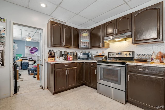 kitchen featuring under cabinet range hood, dark brown cabinetry, a drop ceiling, light countertops, and stainless steel range with electric stovetop