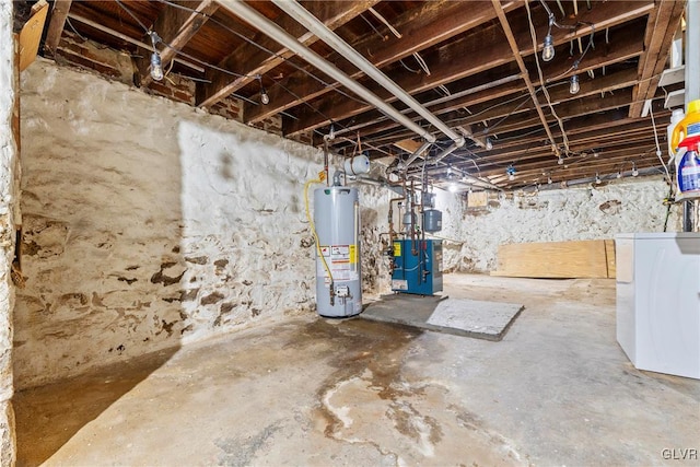 unfinished below grade area featuring water heater, a heating unit, and washer / clothes dryer