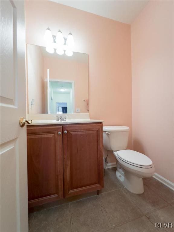 bathroom featuring vanity, toilet, baseboards, and tile patterned flooring