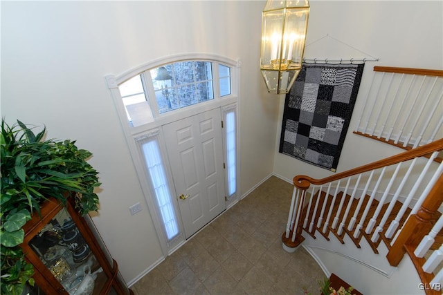 foyer featuring stairs and baseboards