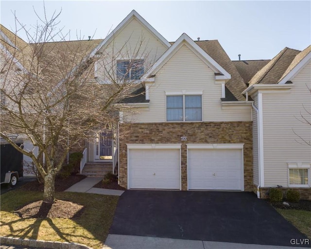 view of front of property featuring driveway, a shingled roof, and a garage