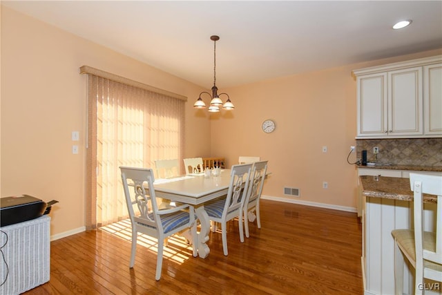 dining area featuring baseboards, visible vents, recessed lighting, light wood-style floors, and a chandelier