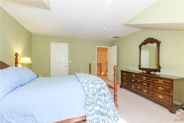 bedroom with visible vents, light colored carpet, and vaulted ceiling