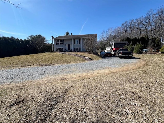 single story home with covered porch, driveway, and a front lawn