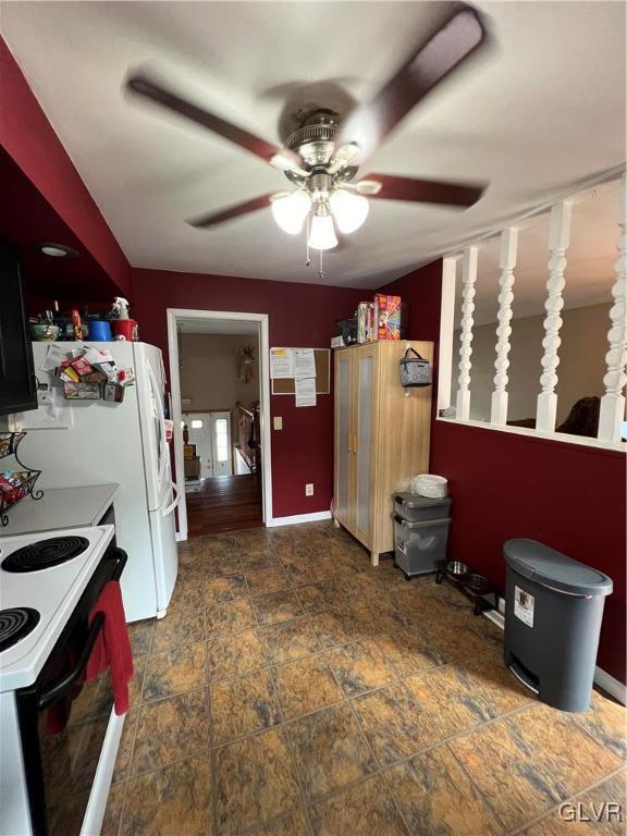 kitchen featuring freestanding refrigerator, stone finish floor, electric stove, and ceiling fan