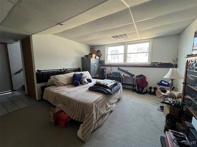 carpeted bedroom with visible vents and a paneled ceiling