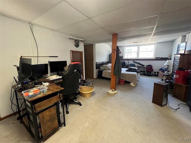 carpeted office with a paneled ceiling