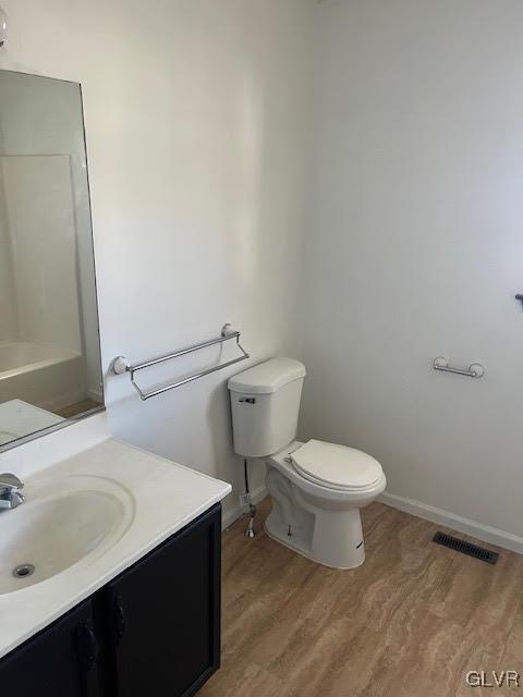 full bathroom featuring visible vents, toilet, vanity, and wood finished floors