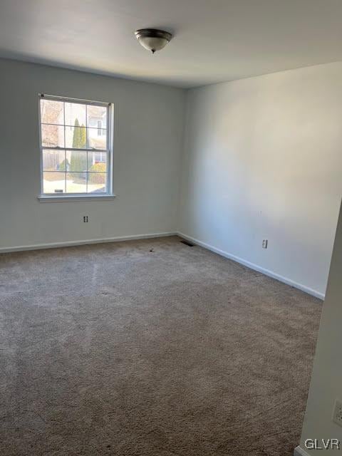 spare room with visible vents, baseboards, and carpet