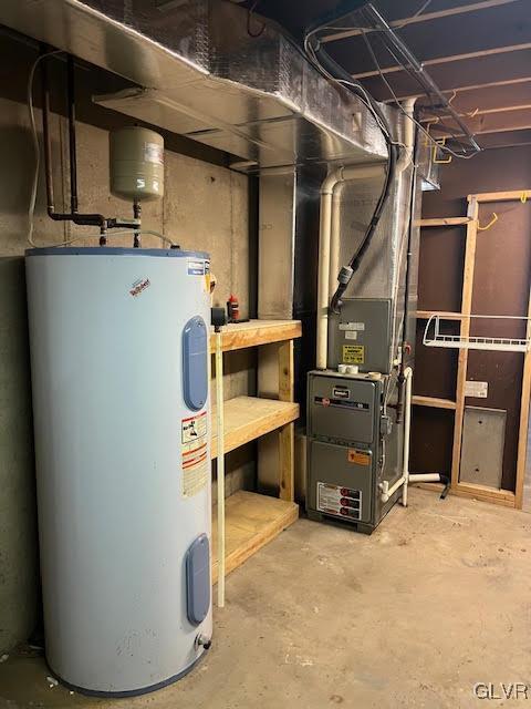 utility room featuring heating unit and electric water heater