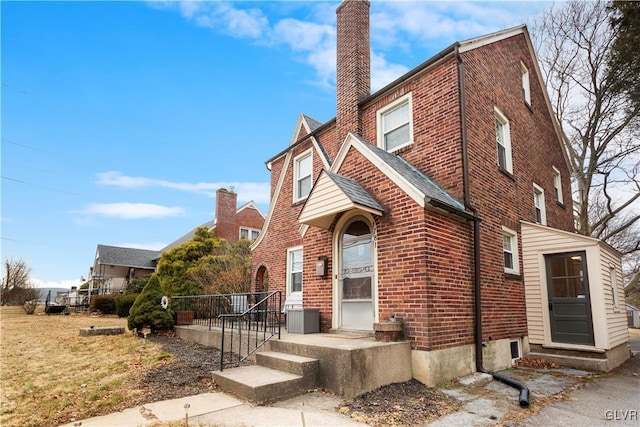 view of front of house featuring brick siding and a chimney