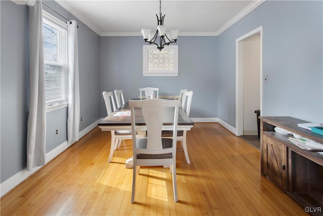 dining area with baseboards, light wood-style floors, an inviting chandelier, and crown molding