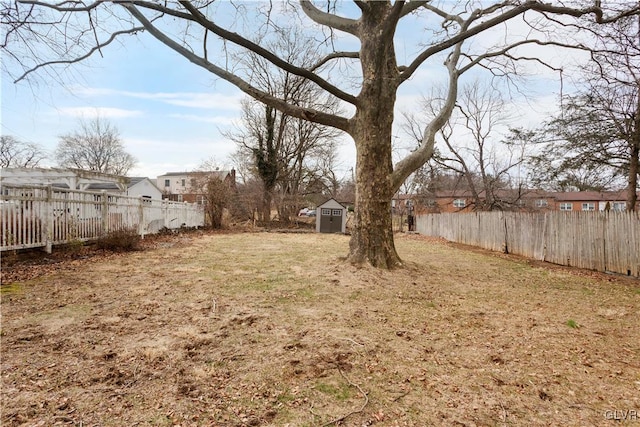 view of yard featuring an outbuilding, a storage unit, and fence