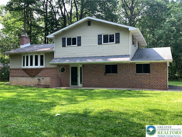 3965 Blacksmith Rd, Weisenberg Twp, PA 18066 - tri-level home with brick siding, a front yard, a chimney, and a shingled roof