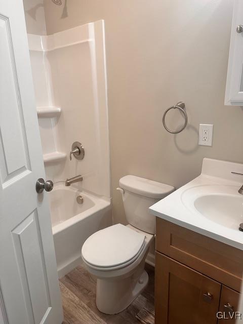 bathroom featuring shower / bathtub combination, toilet, wood finished floors, and vanity