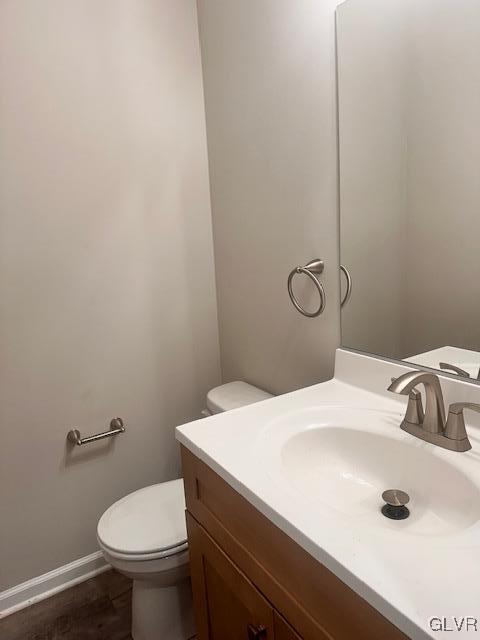 bathroom featuring vanity, toilet, and baseboards