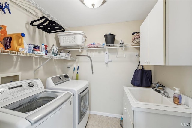 laundry area featuring a sink, baseboards, cabinet space, and washer and clothes dryer