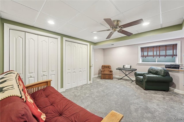 carpeted living area with recessed lighting, baseboards, and a drop ceiling