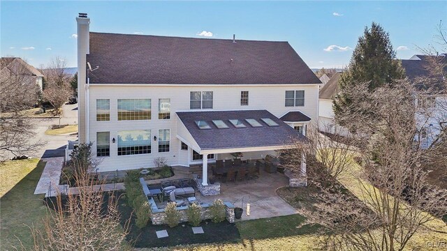 rear view of property with a patio area and a chimney