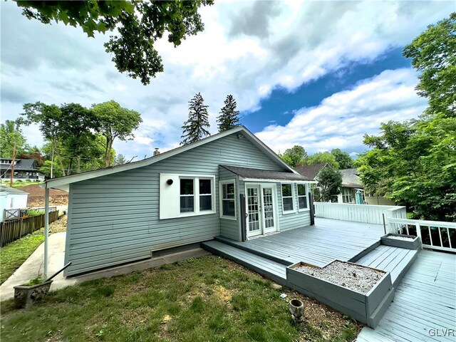 back of house with fence and a wooden deck