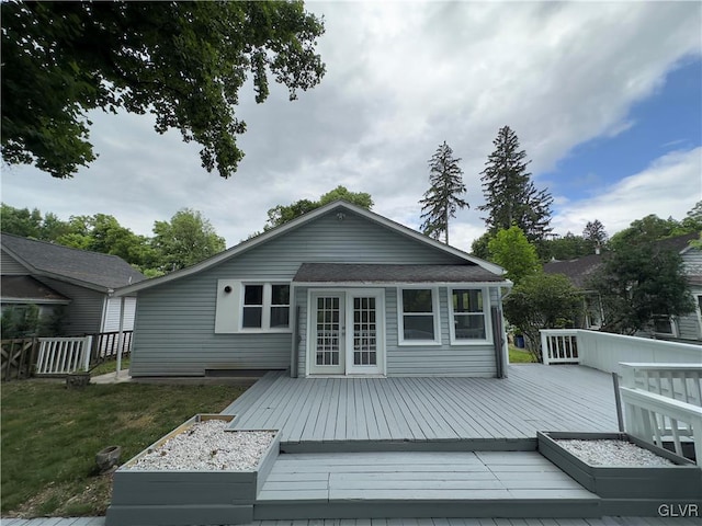 back of property featuring a wooden deck, a yard, and french doors