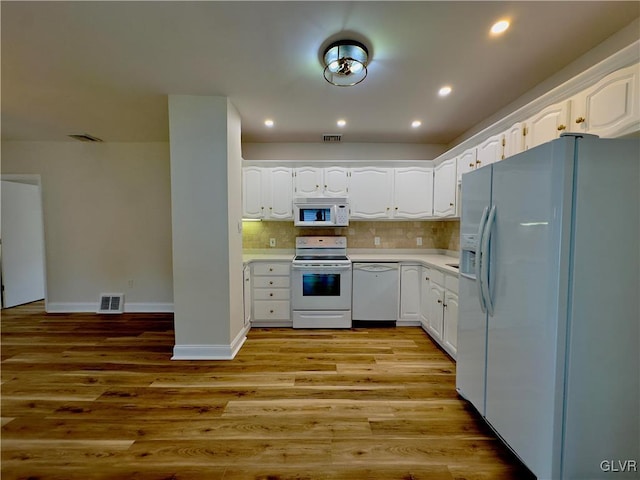 kitchen featuring white appliances, visible vents, light wood finished floors, light countertops, and white cabinetry