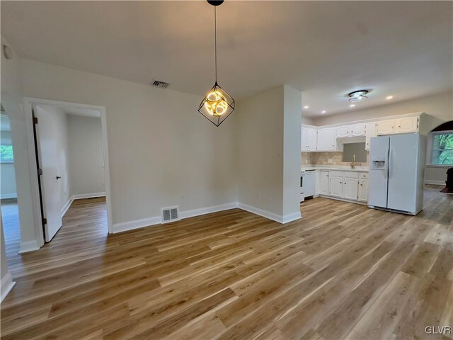 interior space featuring light wood finished floors, visible vents, and baseboards