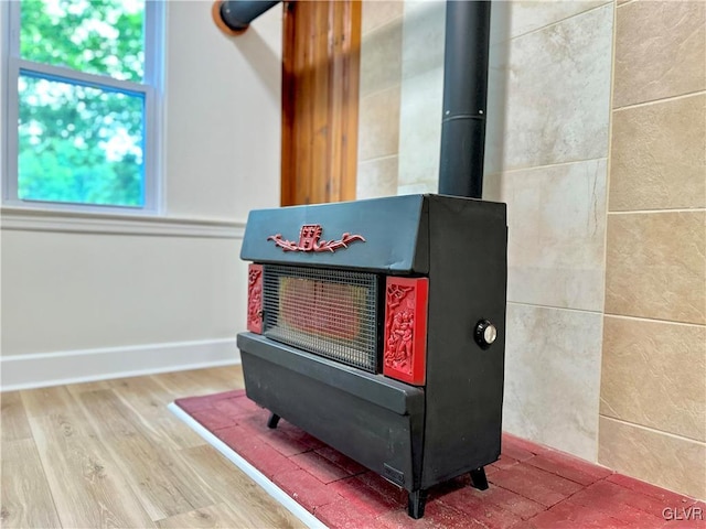 details with a wood stove, wood finished floors, and baseboards