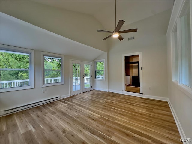 spare room featuring a baseboard radiator, baseboards, light wood-style floors, and vaulted ceiling