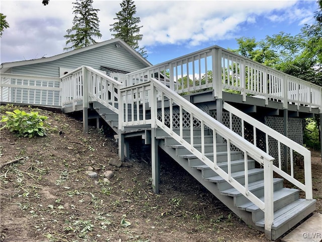 rear view of house featuring stairway and a deck