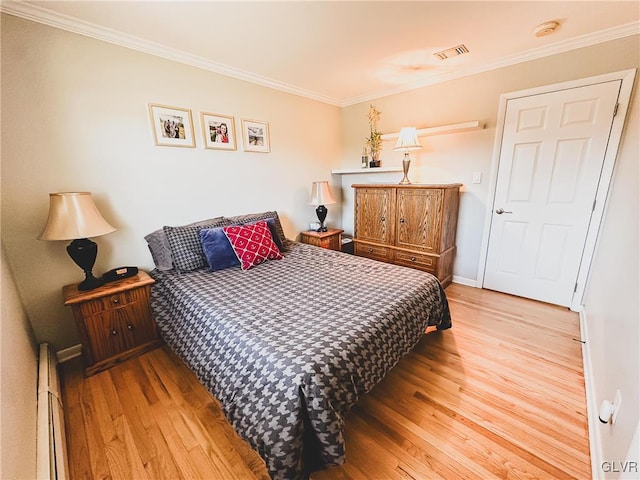 bedroom with visible vents, a baseboard heating unit, crown molding, baseboards, and wood finished floors