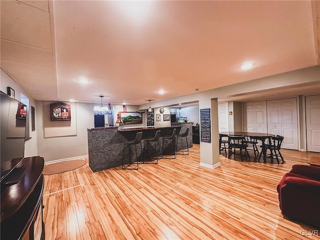 bar with recessed lighting, a community bar, light wood-style floors, and baseboards