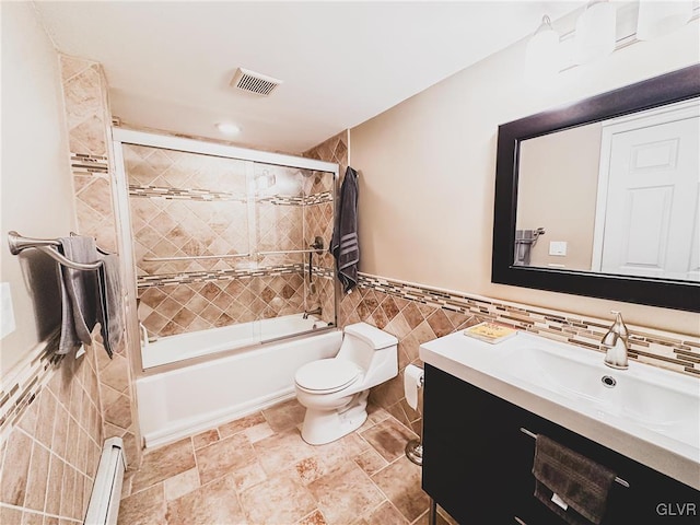 bathroom with toilet, shower / bath combination with glass door, tile walls, a baseboard radiator, and vanity