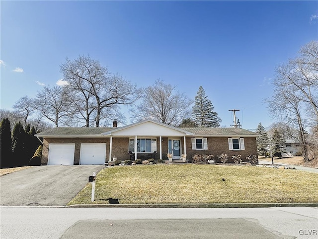 view of front of house with a front lawn, an attached garage, brick siding, and driveway