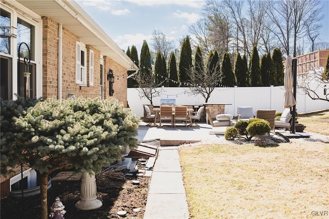 view of yard featuring outdoor dining space, a patio, and fence